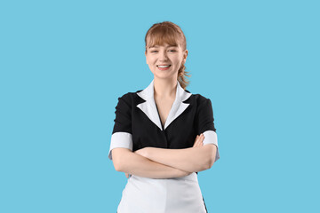 Wall Mural - Young chambermaid on blue background