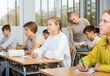 © JackF - Teen boys and girls sitting at desk in classroom full of pupils during lesson