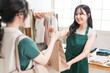 © buritora - アパレルショップでお客様に紙袋を渡す販売員・スタッフ