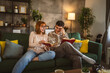 © Miljan Živković - man and woman caucasian adult couple read books at home on sofa bed