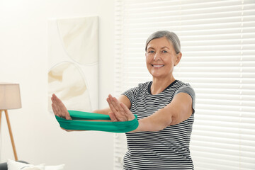 Sticker - Senior woman doing exercise with fitness elastic band at home