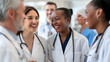 © Kanlayarawit - A group of four doctors in white coats and stethoscopes are talking and laughing together. Black, Asian and white doctors are enjoying themselves with each other on a blurred hospital background.
