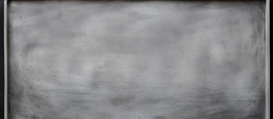 A close up of a chalkboard with a black frame, showing grey tints and shades like a monochrome photograph. The cloud pattern resembles cumulus clouds, creating a sense of darkness against the horizon
