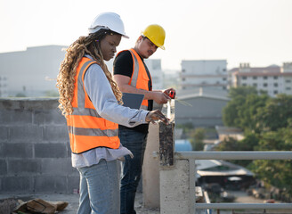 Worker engineer African woman working with caucasian worker at construction site	