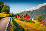 Fototapeta Natura - Spectacular summer scene of Lofthus village with red wooden houses, Hordaland county, Norway. Wonderful morning view of Hardangerfjord fjord. Beauty of countryside concept background.