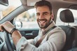 © ffunn - Handsome young man is driving a car and smiling. He is sitting on the steering wheel and looking at camera