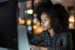 © vefimov - Woman with curly hair is sitting at desk and looking at computer screen