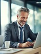 © vefimov - Man in suit is smiling and typing on laptop
