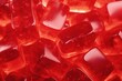 Background with red jelly candies lying on it, soft transparent marmalade cubes.