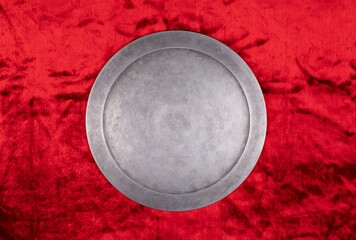 Wall Mural - ancient round silver shield on a red background