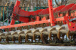 A tillage device attached to a large tractor. Side view