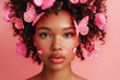 Art portrait of an African American girl with pink butterflies in her hair on a studio pink background with copy space. The concept of naturalness of cosmetic products and cosmetology