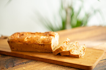 Wall Mural - Homemade raisin muffin cut into slices on a wooden background close-up