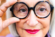 © Raul Mellado - close up portrait of a beautiful senior woman putting on glasses looking at camera, concept of eye health in elderly people and active lifestyle