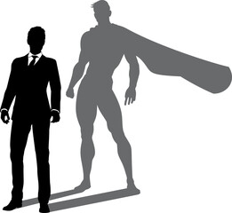 A superhero business man revealed by his shadow silhouette as a super hero in a cape