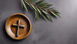 Wooden cross, ceremonial dish, olive branch on gray background. Still life photography. Ash Wednesday, Faith, religiosity and Christianity. Religious symbols, banner, copy space.
