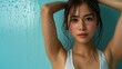 Portrait of young Asian woman show her armpit isolated on light blue background.