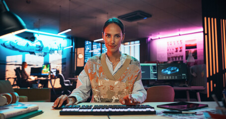 Aufkleber - Portrait of a Female Software Developer Writing Code in a Creative Office with Neon Lights. Young Woman Focused on Typing on Keyboard and Working on Desktop Computer. Point of View of Screen Monitor 