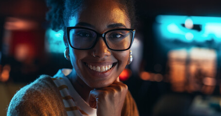 Poster - Close Up Portrait of a Young Black Woman with Glasses, Looking at Camera, Smiling in a Creative Office. Beautiful Diverse Female Working for her Dream Agency, Feeling Empowered