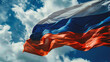 Russian flag waving in the wind against a blue sky with white clouds