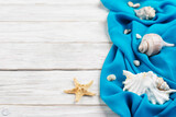 Fototapeta Tęcza - Seashells, blue fabric and starfish on white planks vacation planning background flat lay with copy-space