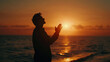 silhouette of a man raising his hands at sunset, unrecognizable side view