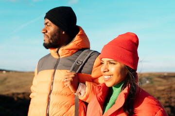 Wall Mural - happy couple in love walking along countryside at the sunset.  Love, hiking and active lifestyle concept