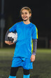 © PoppyPix - lovely Caucasian little footballer girl in a blue uniform posing with a soccer ball, medium shot. High quality photo