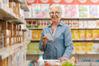 © StockPhotoPro - Happy senior woman buying groceries at the store
