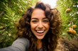 Young happy woman taking selfie in the orchard. Portrait of smiling attractive woman in the nature.