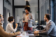 © dusanpetkovic1 - An african american chief is standing at meeting room with her team and collaborating on a project.
