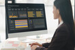 Asian businesswoman or accountant are analyzing data charts, graphs, and a dashboard on desktop screen in order to prepare a statistical report and discuss financial data in an office.