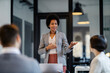 © Dusan Petkovic - An interracial manager is presenting new business strategy to her team at boardroom.