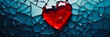 A shattered red glass heart on dark blue background symbolizing heartbreak, broken relationship and emotional pain. Concept of lost love or betrayal.