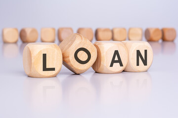 Poster - four wooden cubes with the text 'LOAN' on a light gray background signify a financial concept related to borrowing money or lending funds