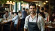 Portrait of a smiling waiter in a busy restaurant
