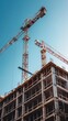 © vadymstock - A construction site with a crane and building framework set against a clear blue sky, capturing the progress and ambition of urban development and architectural growth.