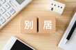 © ELUTAS - 別居の文字が入ったブロック、電卓、おもちゃの家、スマホ
