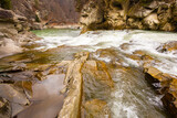Fototapeta Na ścianę - Scenic spring waterfall in Ukrainian Carpathians. Beautiful river flow among huge brown rocks
