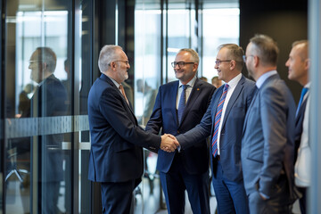 Wall Mural - photo of two groups of business men shaking hands in an office