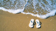 a pair of flip-flops, abandoned on a sandy beach 