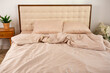 light beige satin bed linen and pillows on the bed