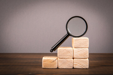 Wall Mural - Search and research concept. Magnifying glass on wooden blocks