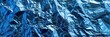 Intense Blue Foil: Closeup of Metal Foil Element with Crinkled Details and Mirrored Chrome Texture as Background