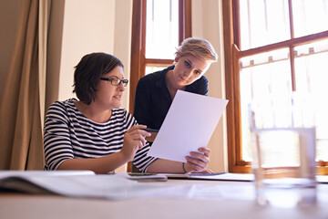 Women, planning and collaboration on report in office with teamwork, support and feedback on project. People, talking and advice for paperwork, proposal and information in document for business