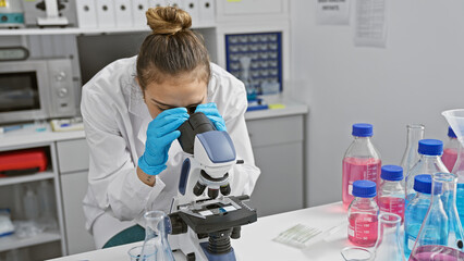 Canvas Print - Young beautiful hispanic woman scientist using microscope analysing sample at laboratory