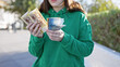 © Krakenimages.com - Young woman holding hungarian forint banknotes outdoors in a green park