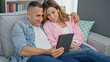 © Krakenimages.com - Man and woman couple using touchpad sitting on sofa at home