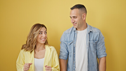 Poster - Man and woman couple smiling confident standing together over isolated yellow background