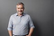 © PNG&Background Image - Middle-aged man wearing a blue office shirt confidently standing with arms crossed on a dark grey background with copy space.